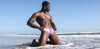 Man promoting gay underwear in gay swim suit on beach